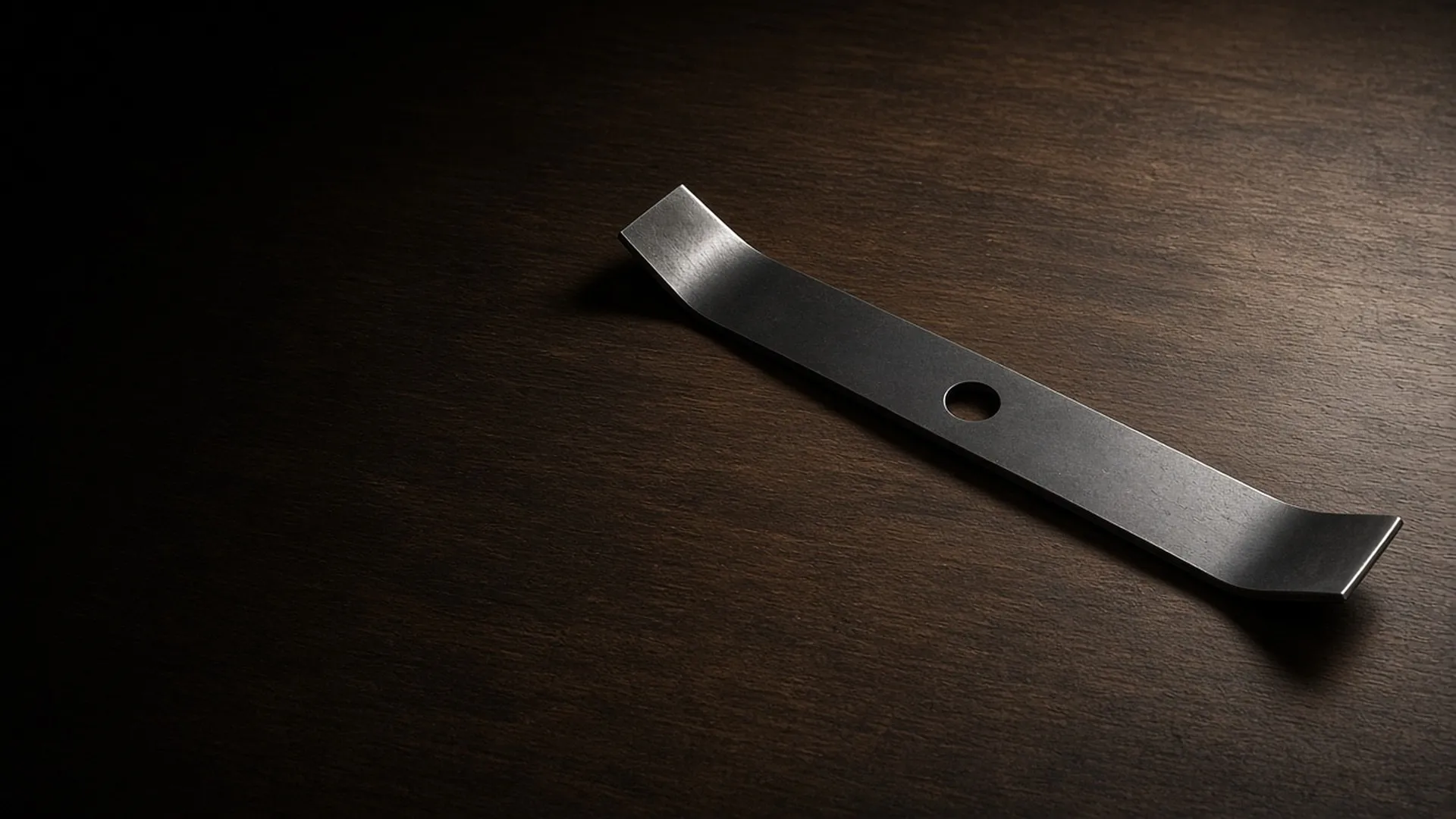 A clean mower blade on a workbench