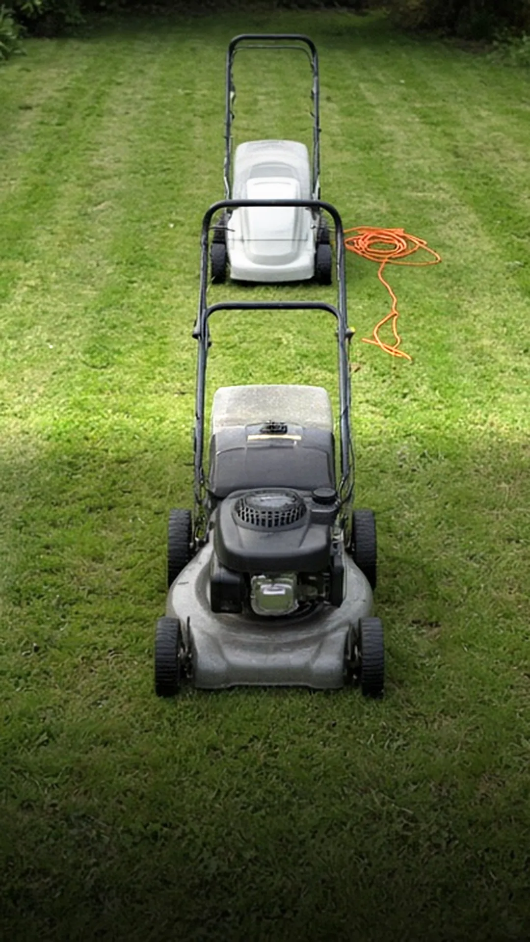 A gas mower and a corded electric mower side by side