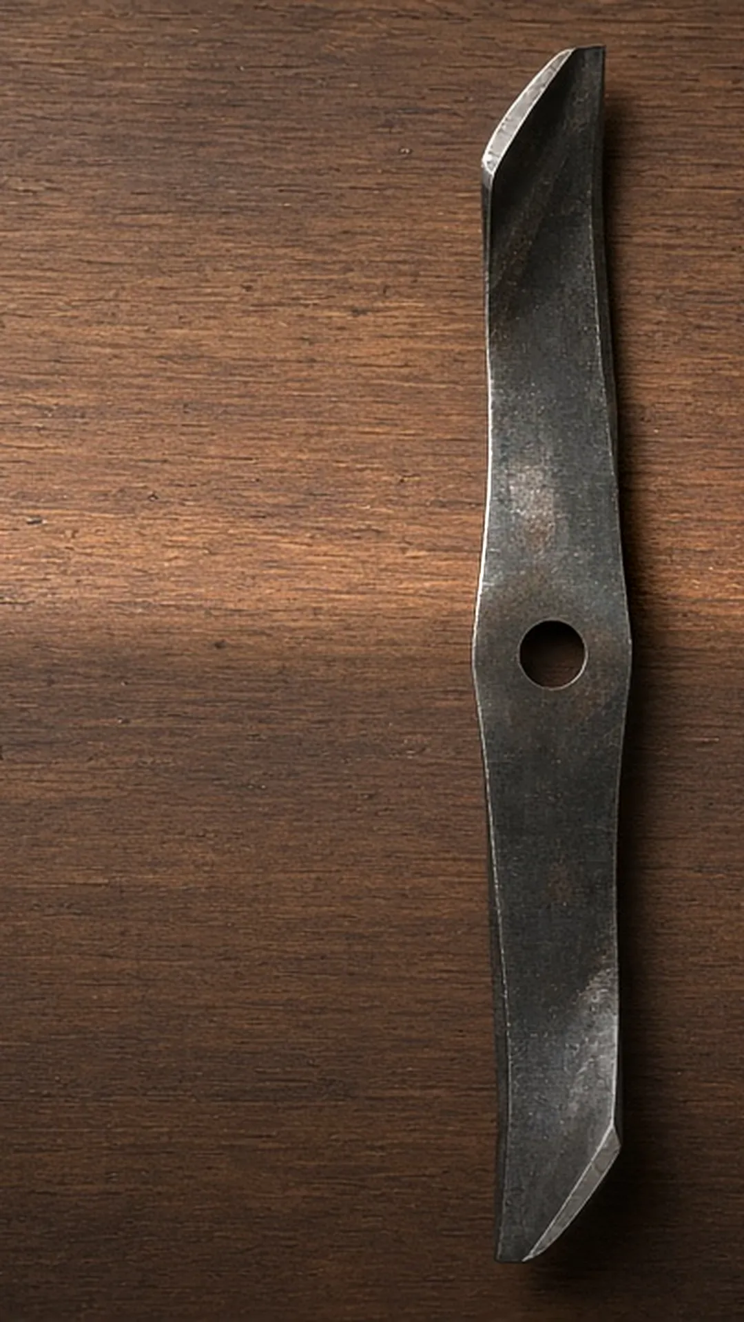 A clean mower blade on a workbench