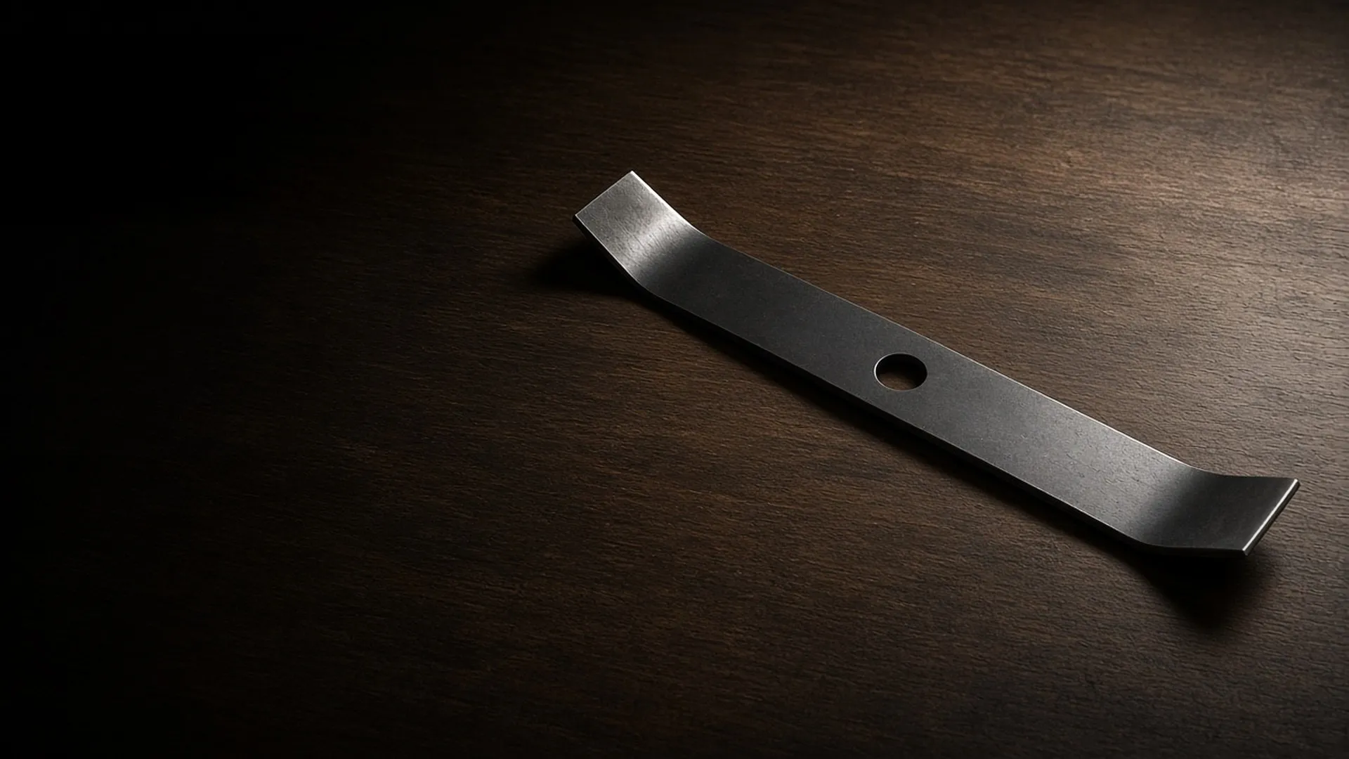 A clean mower blade on a workbench